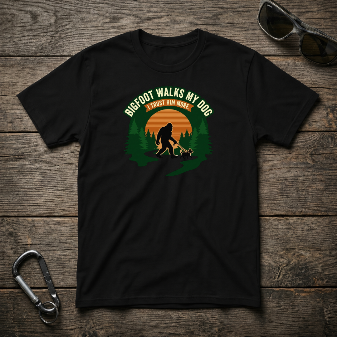 Black graphic T-shirt by Designed For The Wild Co featuring Bigfoot walking a dog on a softstyle fabric.