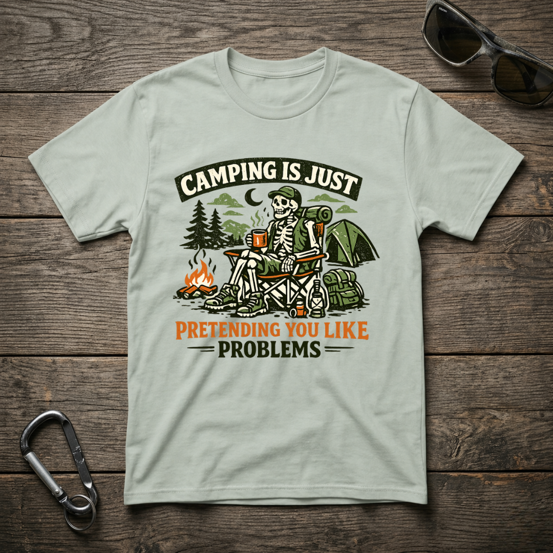 Graphic T-Shirt by Designed For The Wild Co featuring "Camping Is Just Pretending" text and a casual, garment-dyed fabric.