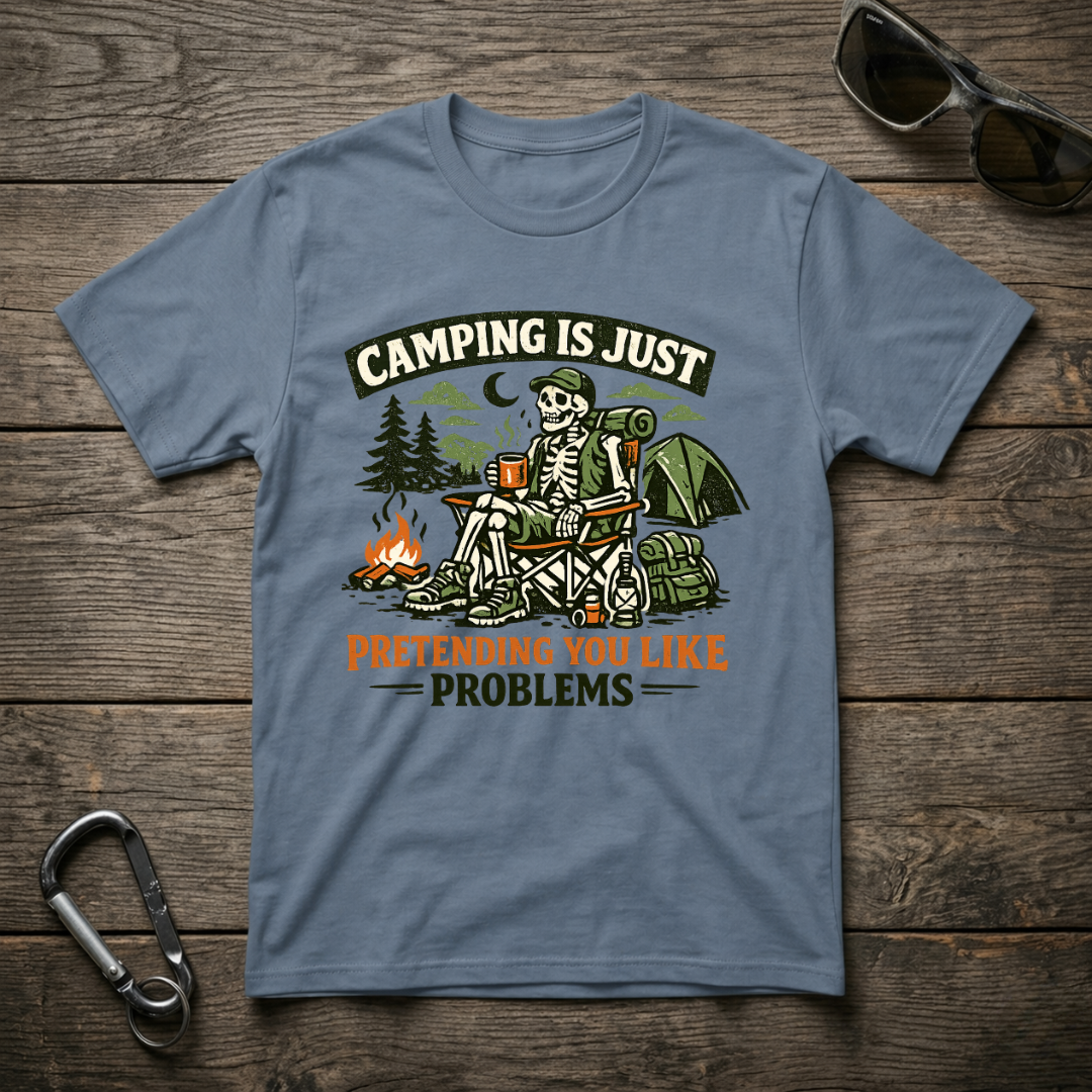 Blue graphic T-shirt from Designed For The Wild Co featuring camping-themed "Camping Is Just Pretending" print.