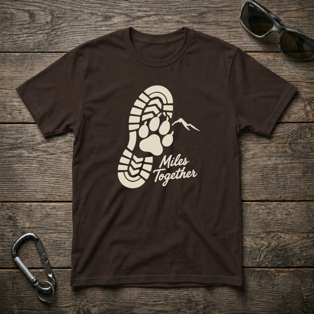 Dark chocolate Miles Together Paw graphic T-shirt by Designed For The Wild Co featuring a softstyle fabric and paw print design.