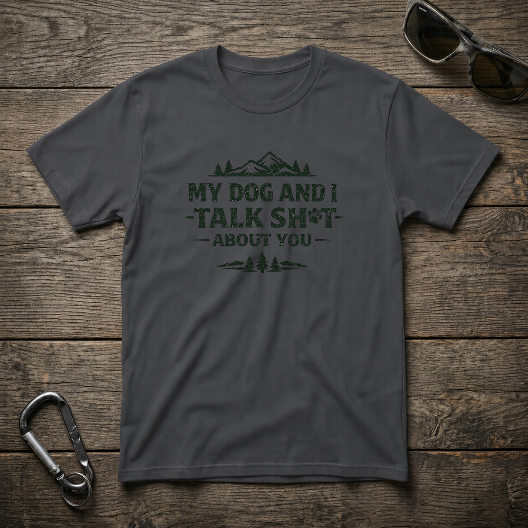 Dark heather graphic T-shirt from Designed For The Wild Co featuring "My Dog and I Talk Sh*t" slogan in bold text.