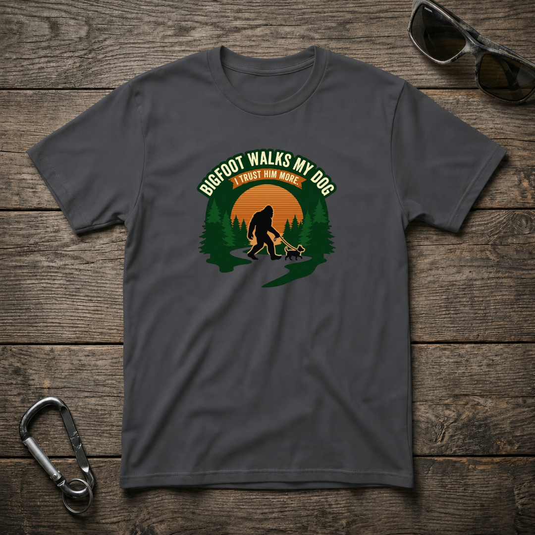 Dark heather graphic T-shirt by Designed For The Wild Co featuring Bigfoot walking a dog design on softstyle fabric.