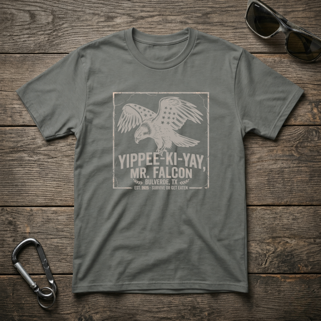 Grey graphic T-shirt by Designed For The Wild Co, featuring the Yippee Ki Yay Mr. Falcon design on soft, garment-dyed fabric.