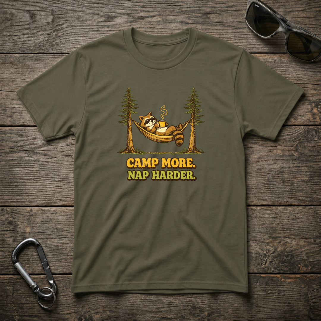 Military green Camp More Nap Harder graphic T-shirt by Designed For The Wild Co featuring bold outdoor-themed text and design.