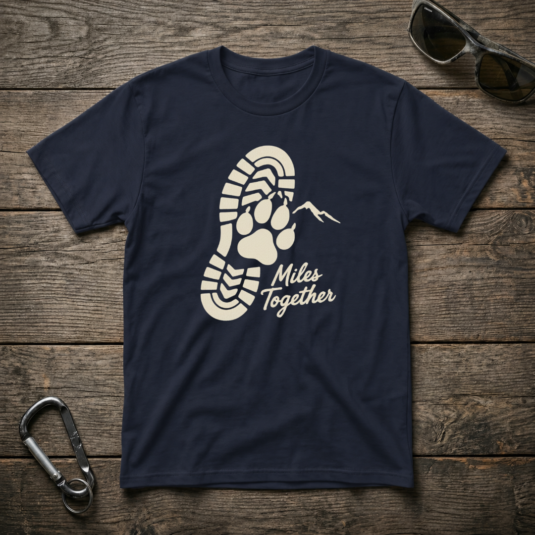 Navy Miles Together Paw graphic softstyle T-shirt by Designed For The Wild Co displayed on a flat surface.