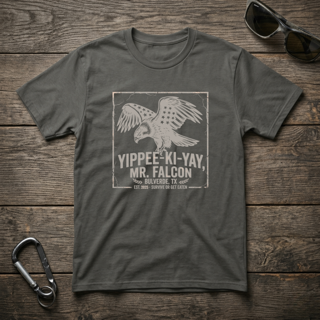 Graphic Yippee Ki Yay Mr. Falcon T-shirt by Designed For The Wild Co, featuring a colorful falcon design on a garment-dyed fabric.