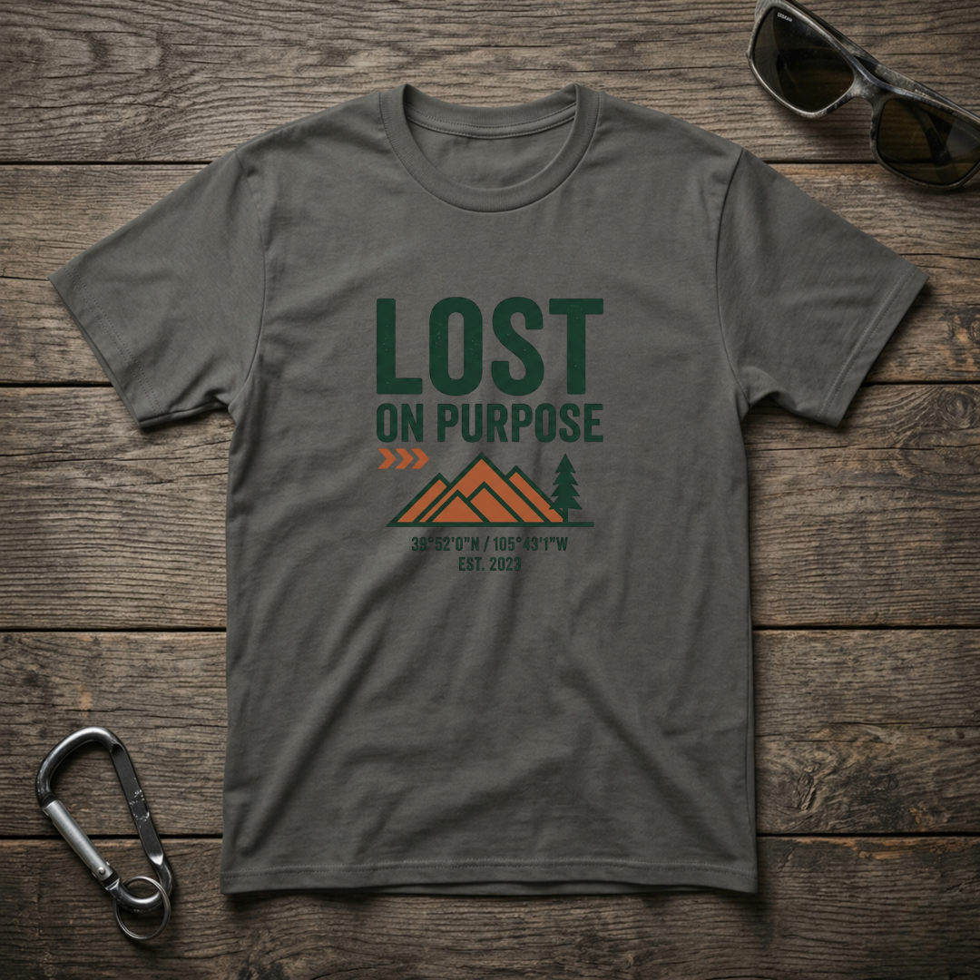 Graphic T-shirt from Designed For The Wild Co with a worn-in look and "Lost on Purpose" print in earthy tones.