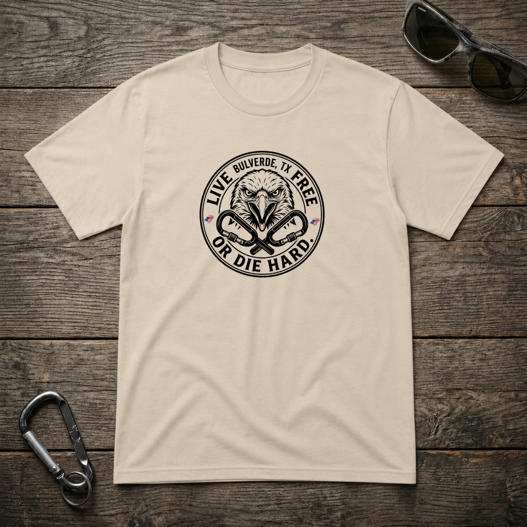 Designed For The Wild Co heavyweight graphic T-shirt featuring "Live Free Or Die Hard" slogan on a sand-colored fabric.