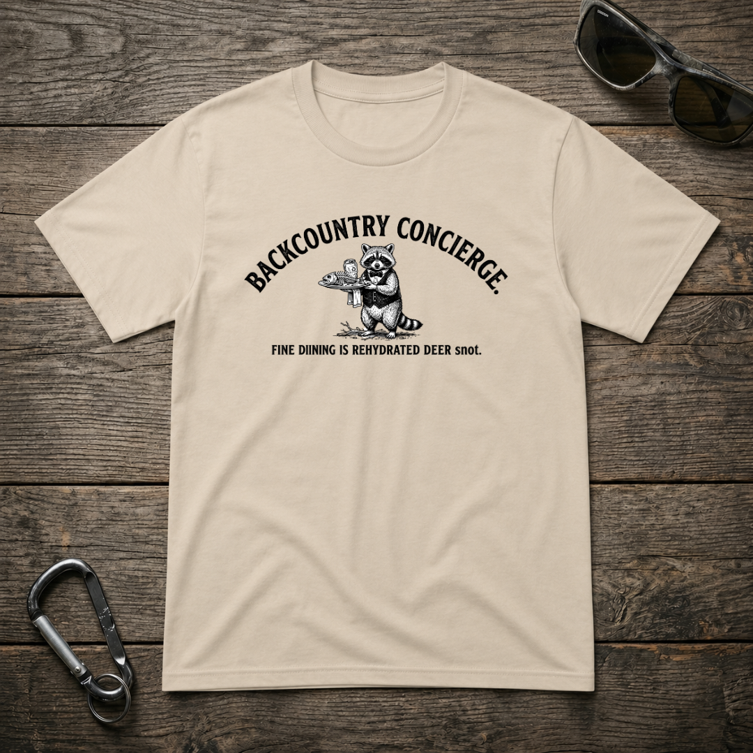 Designed For The Wild Co Backcountry Concierge heavyweight graphic T-shirt in sand, featuring outdoor-themed design and comfortable fit.